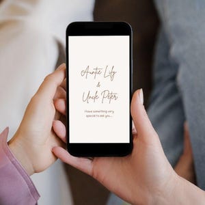 May include: A black smartphone screen shows cursive text on a cream background. The text reads "Auntie Lily & Uncle Peter" and below it, "I have something very special to ask you..."