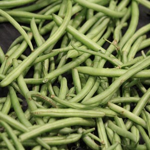 May include: A close-up image of a bunch of fresh green string beans. The beans are arranged in a random pattern, with some beans overlapping others.
