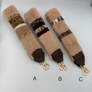 Pode incluir: Três alças de bolsa fofas de pele sintética em diferentes designs. Cada alça apresenta uma base bege com detalhes estampados em marrom, bordô e creme. As extremidades em couro marrom escuro e os fechos de metal dourado completam o visual. As alças são rotuladas A, B e C.