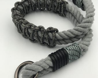 May include: A gray rope leash with a black and gray accent and a silver ring. The rope is decorated with a silver beaded trim.