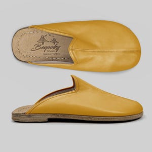 Close-up detail of the wide toe box on handmade mustard leather mules, revealing meticulous stitching and the premium buffalo leather texture.