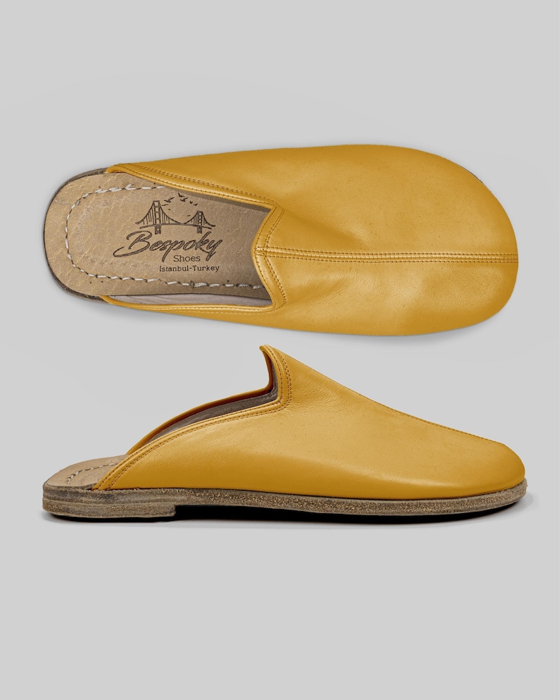 Close-up detail of the wide toe box on handmade mustard leather mules, revealing meticulous stitching and the premium buffalo leather texture.