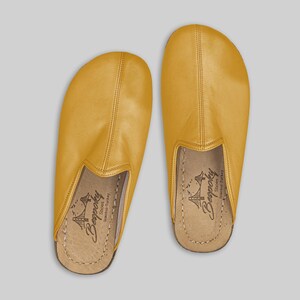 Men's mustard leather slip-on mules worn on foot, demonstrating the natural fit and wide toe box for ultimate barefoot comfort and healthy foot alignment.