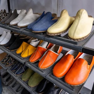 A display of various colorful shoes on shelves, including casual and formal styles.