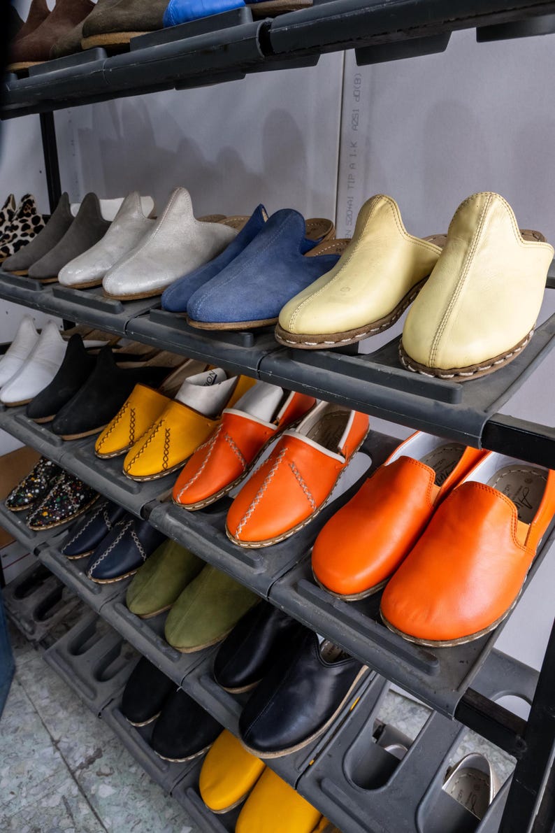 A display of various colorful shoes on shelves, including casual and formal styles.