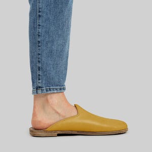 Side profile of men's handmade mustard leather mules, highlighting the flexible zero-drop sole and wide toe box design for natural foot alignment.