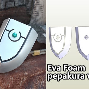 May include: A white shield with a black outline and a green gem in the centre. The shield is a 3D model made from Eva foam and is labelled "Eva Foam pepakura ver".