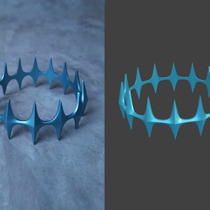 May include: A blue metal crown with a pointed design. The crown is made of a series of connected points that form a circle.