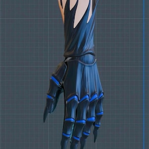 May include: A dark blue, stylized hand with sharp, pointed fingers and blue accents. The hand appears to be a costume or prop, with a detailed design and a textured appearance. The wrist area has a light beige color.