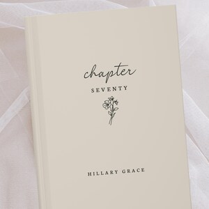 Könnte beinhalten: Ein cremefarbenes Buch mit dem Wort "chapter" in Schreibschrift oben. Darunter steht das Wort "SEVENTY" zentriert, mit einer kleinen floralen Illustration. Der Name des Autors, "HILLARY GRACE", steht unten.
