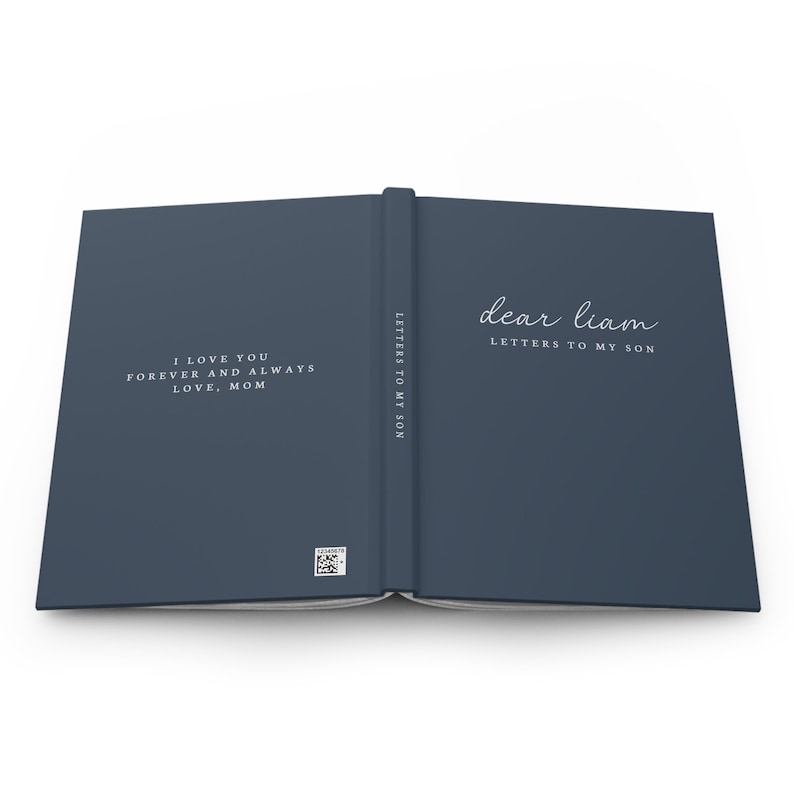 May include: Open journal with a dark blue cover. The left page reads "I LOVE YOU FOREVER AND ALWAYS LOVE, MOM" in white script. The right page says "dear liam LETTERS TO MY SON". The spine reads "LETTERS TO MY SON".