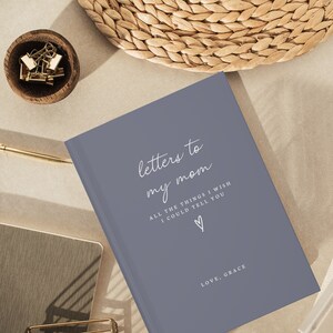 Peut inclure: Un journal gris avec le texte "letters to my mom" et "ALL THE THINGS I WISH I COULD TELL YOU" en blanc. Le journal a &eacute;galement un petit c&oelig;ur et le texte "LOVE, GRACE" en blanc.