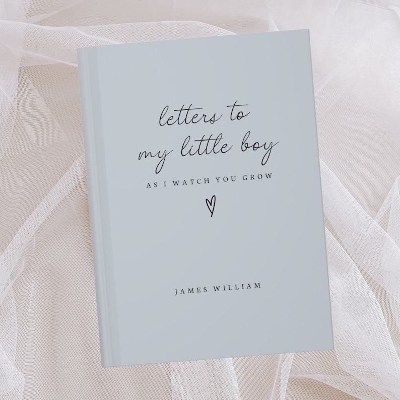 May include: A light blue journal with the text "letters to my little boy as I watch you grow" and a heart symbol. The name "JAMES WILLIAM" is printed at the bottom of the cover.