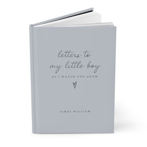May include: A gray hardcover journal with the text "letters to my little boy as i watch you grow" and a small heart symbol. The name "JAMES WILLIAM" is printed below the text.