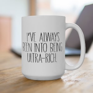 May include: White ceramic coffee mug with black text that reads "I've always been into being ultra-rich."