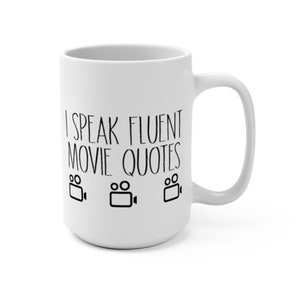May include: White ceramic coffee mug with black text that reads "I speak fluent movie quotes" and three black film camera icons.