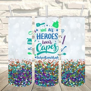 Pode incluir: Três copos de aço inoxidável com tampas e canudos. Os copos apresentam um design com o texto "NOT ALL HEROES wear CAPES" e gráficos coloridos. A parte inferior dos copos tem um design de glitter.