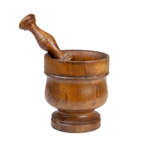 May include: A medium-brown wooden mortar and pestle set featuring a cylindrical bowl with a flared rim and a sturdy base. The matching wooden pestle has a contoured handle and a rounded grinding end, resting inside the bowl at an angle.