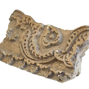 May include: A rectangular wooden block for textile printing featuring a carved relief pattern of swirling floral and leaf motifs. The wood has a light brown, weathered finish with visible grain and deep, intricate indentations.