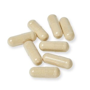 May include: A group of eight beige capsules, scattered on a white background.