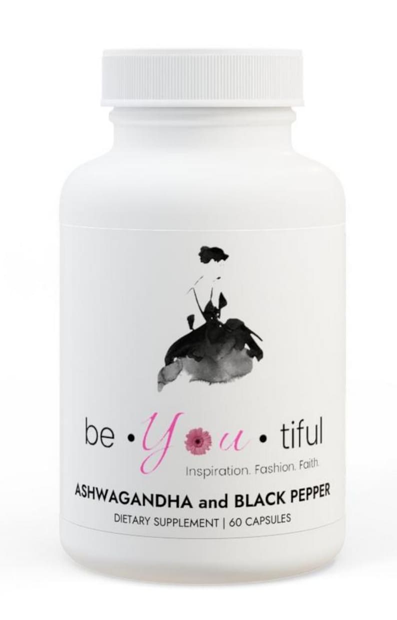 May include: White bottle with a black and white illustration of a woman in a dress. The bottle is labeled "be &bull; Yutiful Inspiration. Fashion. Faith ASHWAGANDHA and BLACK PEPPER DIETARY SUPPLEMENT | 60 CAPSULES"