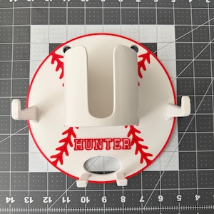 May include: A white ceramic mug with a black handle and the text "But First, Coffee" in a bold, black font. The mug is set against a blurred background, suggesting a cozy setting.