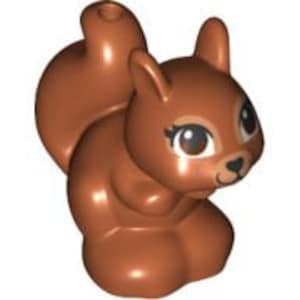 Op de afbeelding: Een bruin plastic eekhoornbeeldje met een pluche staart, grote ogen en een schattige glimlach.
