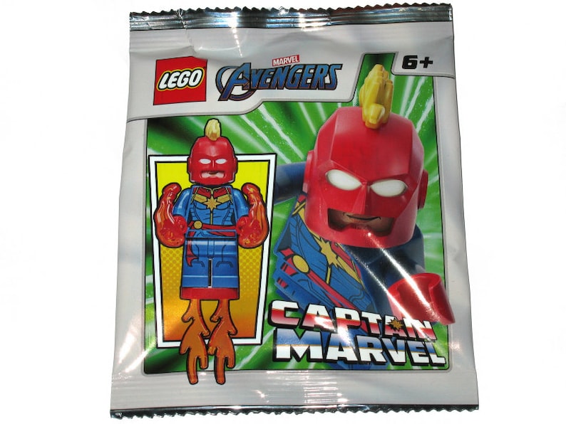 Pu&ograve; includere: Una bustina sigillata LEGO Marvel Avengers con Captain Marvel. La confezione mostra i loghi LEGO e Avengers, un'indicazione di et&agrave; 6+ e una grafica della minifigure di Captain Marvel con tuta rossa e blu, stella gialla ed effetti di fiamma arancioni.