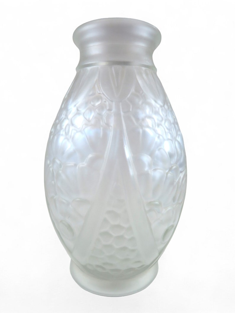 Op de afbeelding: Een witte, gematteerde glazen vaas met een reli&euml;f van bloemen. De vaas heeft een rond lichaam en een smalle hals.