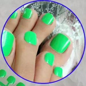May include: Close-up of a person's feet with bright green nail polish on their toes.