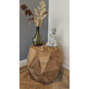 Könnte beinhalten: Ein hölzerner Beistelltisch mit geometrischem Design, der eine grüne Glasvase mit getrockneten Blumen und eine kleine Buddha-Statue trägt. Der Tisch ist aus hellbraunem Holz und hat einen Durchmesser von ca. 61 cm.