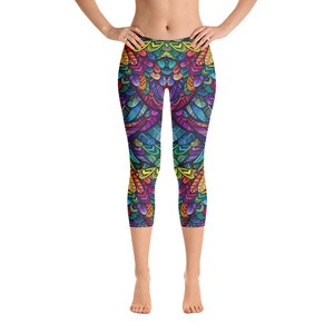 May include: Capri-length leggings with a vibrant, symmetrical design in a spectrum of colors including blue, green, yellow, orange, and purple. The leggings feature a detailed, feather-like pattern, creating a bold and eye-catching look. These leggings are perfect for yoga or casual wear.