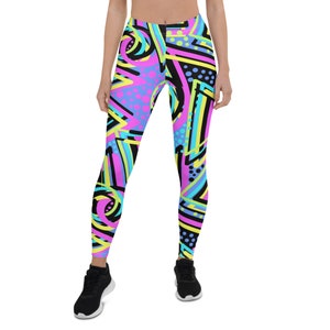 May include: Black leggings with a colorful geometric pattern in pink, blue, yellow, and green. The pattern features abstract shapes, lines, and dots.