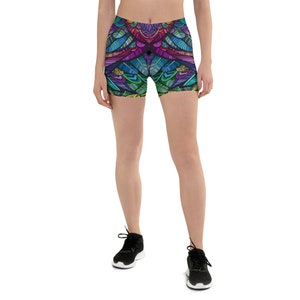 May include: A pair of black athletic shorts with a colorful, abstract, geometric pattern. The pattern features a variety of colors, including pink, blue, green, and yellow.