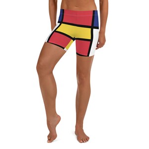 May include: Women's athletic shorts with a geometric pattern in red, yellow, blue, and black on a white background.