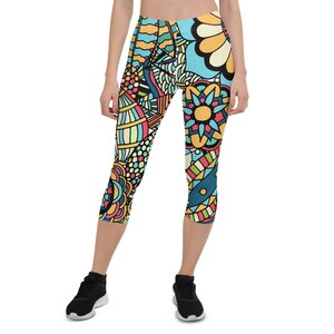 May include: Colorful patterned leggings with a blue, yellow, pink, and green design. The leggings are cropped and have a tight fit.