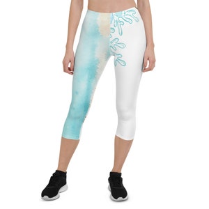 May include: White and blue cropped leggings with a watercolor design on one leg and a white leg with a blue abstract design.