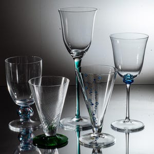Peut inclure: Cinq verres à boire en verre transparent avec différentes formes et styles. Certains verres ont des accents bleus et verts.