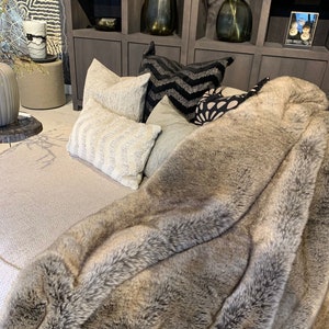 Natural Beige-Gray Furry Throw – An Elegant Accent for Any Interior. This stylish decorative throw in warm hues of beige and gray mimics natural fur, offering comfort and luxury perfect for settings ranging from rustic charm to classic sophistication. Ideal for draping over sofas or beds, it enhances home decor with exceptional design and a cozy ambiance, blending aesthetic appeal with functionality.