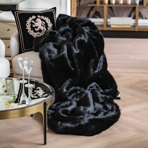 Exclusive Black Faux Fur Blanket – the perfect home decor accent uniting comfort and elegance. This unique blanket, crafted from soft faux fur in a deep black hue, is a luxurious home decoration ideal for contemporary settings and glamorous interiors. It provides warmth on cool evenings while elevating the prestige and designer charm of your living space.