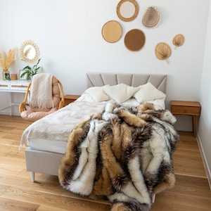 Luxurious faux fur throw blanket made from high-quality synthetic fur is the perfect home decor accent to transform your space with unparalleled comfort and elegance. Its warmth and softness blend seamlessly with boho, glamour, and modern design styles. The natural mix of browns, beiges, whites, and blacks creates an exclusive look reminiscent of real fur, making it not just a practical addition but also a stylish statement piece for any interior.