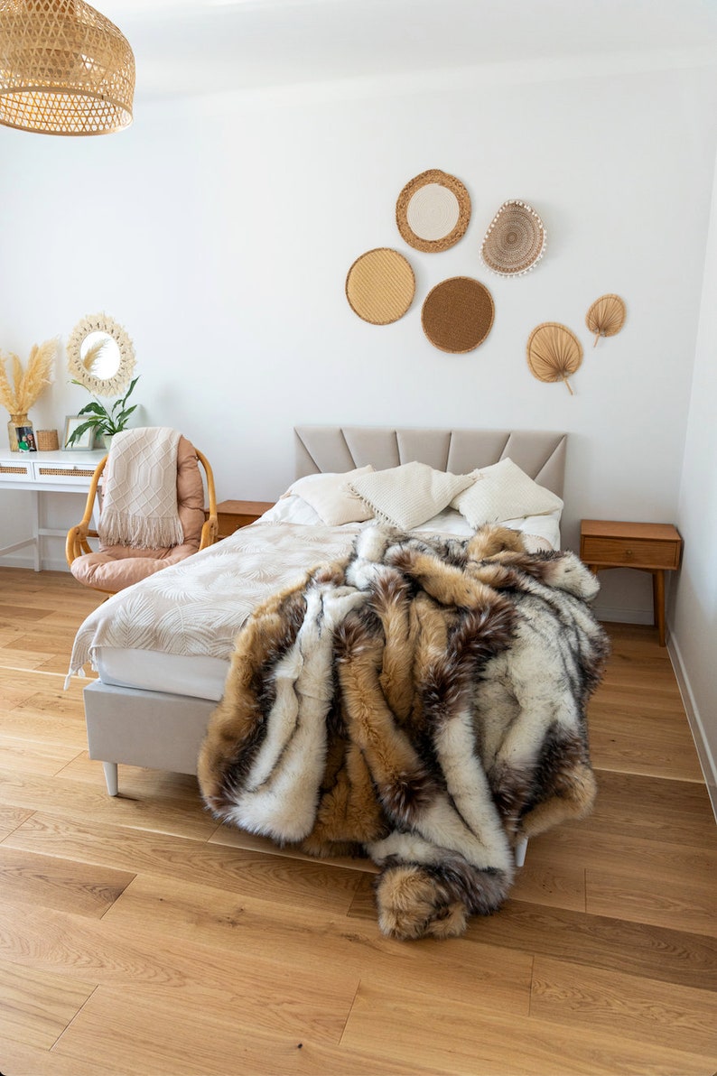 Luxurious faux fur throw blanket made from high-quality synthetic fur is the perfect home decor accent to transform your space with unparalleled comfort and elegance. Its warmth and softness blend seamlessly with boho, glamour, and modern design styles. The natural mix of browns, beiges, whites, and blacks creates an exclusive look reminiscent of real fur, making it not just a practical addition but also a stylish statement piece for any interior.
