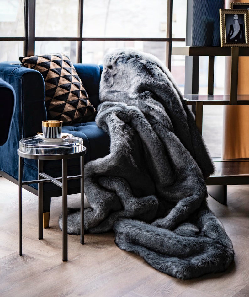 Luxury Graphite Furry Blanket 
Discover our designer furry blanket in captivating graphite and black tones, perfectly designed to enhance your glamorous and modern home decor. Its ultra-soft texture not only infuses your living room or bedroom with warmth and comfort but also serves as a unique decorative accent that highlights elegance and luxury in every setting. Ideal for home decor enthusiasts who value comfort and style, this fur blanket is a practical and chic addition for cool evenings.