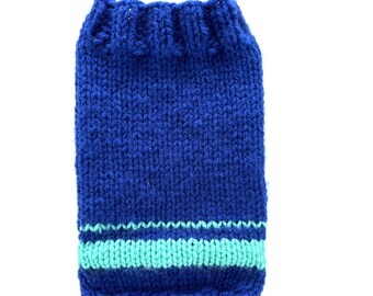 Puede incluir: Un suéter azul tejido para una mascota con una franja turquesa alrededor de la parte inferior.