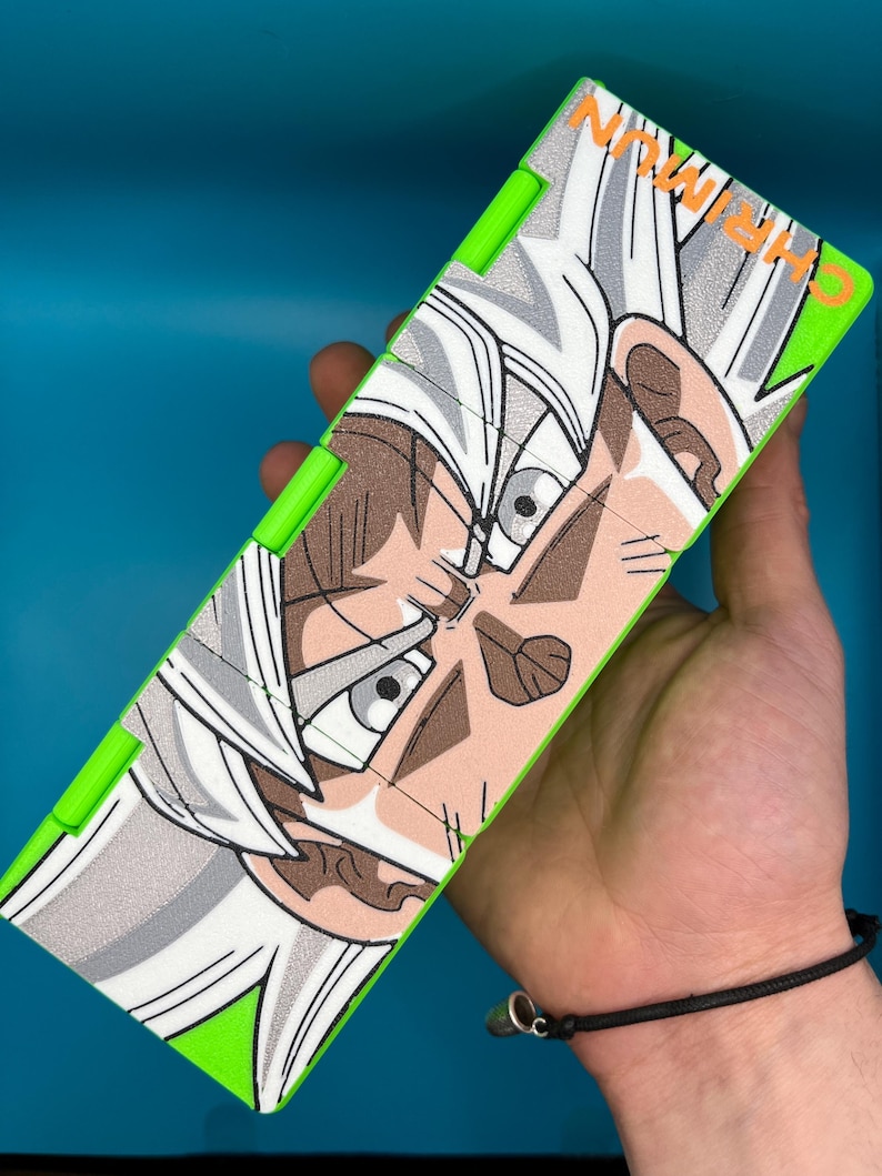 May include: A rectangular puzzle with a green border, displaying a detailed anime character illustration with white and grey hair, brown skin, and focused eyes. The puzzle has the text "CHIRMUN" in white.