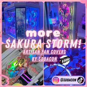 May include: A set of pink and white magnetic fan covers featuring a cherry blossom design. The covers are illuminated with RGB lighting and the text "SAKURA STORM!" is displayed in pink lettering. The text "ARTISAN FAN COVERS BY 3DBACON" is also displayed.