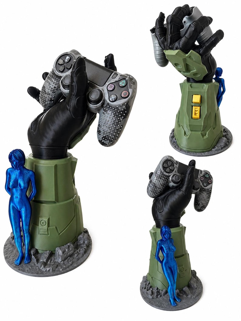 Puede incluir: Un soporte para mando de juegos con una mano negra blindada que emerge de una base cil&iacute;ndrica verde con botones amarillos. Una figura femenina de color azul met&aacute;lico se encuentra junto a la base, sobre una plataforma rocosa de color gris.