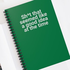 May include: A green spiral notebook with the text "Sh*t that seemed like a good idea at the time" in white.