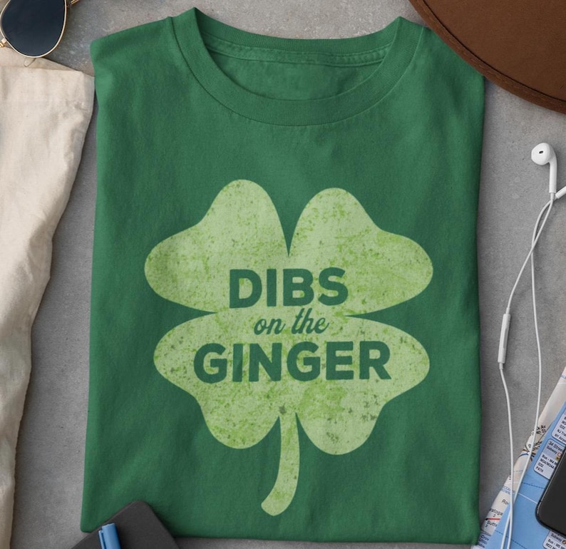 Może przedstawiać: Zielona koszulka z grafiką koniczyny czteroliściennej i tekstem "DIBS on the GINGER".