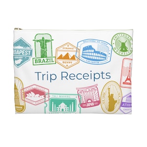 May include: White travel pouch with a zipper closure, featuring colorful stamp-like illustrations of landmarks from around the world. Text on the pouch reads "Trip Receipts". Includes images of the Eiffel Tower, Colosseum, and Taj Mahal.